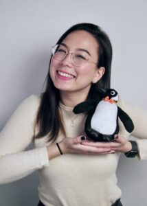 KES holding a stuffed penguin.